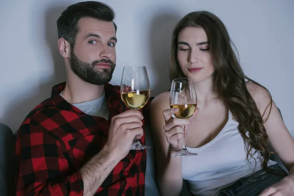 Cheerful man and attractive girl holding glasses of white wine — Stock Photo
