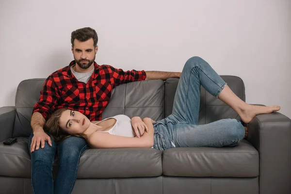 Депресивна молода пара на дивані вдома під час карантину — стокове фото