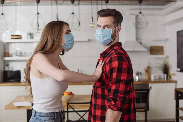 Young girl pushing chest of boyfriend while quarreling with him in kitchen — Stock Photo