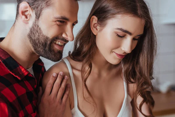 Glücklicher junger Mann berührt Schulter der schönen, lächelnden Freundin — Stockfoto