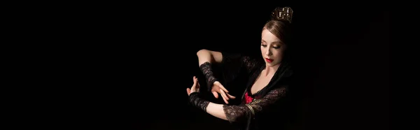 Panoramic concept of attractive dancer in dress gesturing while dancing flamenco isolated on black — Stock Photo