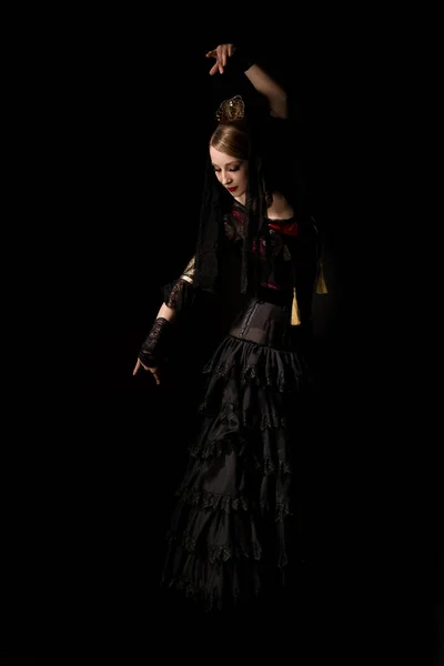 Bonita bailarina en vestido gesto mientras baila flamenco aislado sobre negro - foto de stock