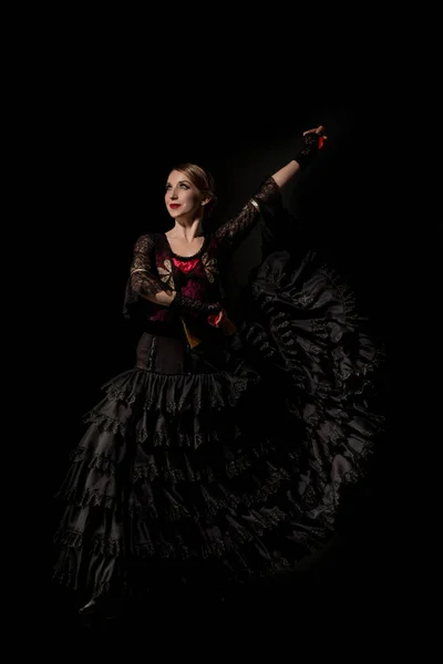 Fröhliche Flamenco-Tänzerin im Kleid, Kastagnetten haltend und isoliert auf Schwarz tanzend — Stockfoto