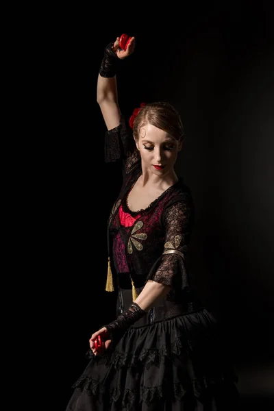 Молодий танцюрист фламенко в сукні тримає кастанець під час танців ізольовано на чорному — стокове фото