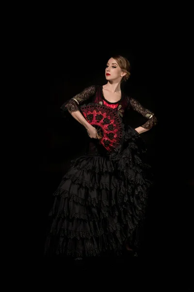 Elegante bailarina con abanico bailando flamenco aislado sobre negro - foto de stock