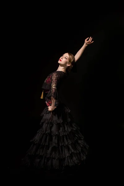 Élégante danseuse avec la main sur la hanche dansant flamenco isolé sur noir — Photo de stock