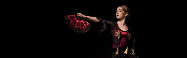 Horizontal crop of elegant woman holding fan and dancing flamenco isolated on black — Stock Photo