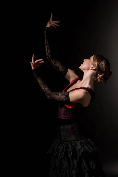 Молода і елегантна жінка жестикулює під час танцю фламенко на чорному — стокове фото