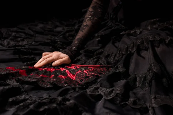 Vista recortada de la joven bailarina flamenca en vestido con abanico aislado sobre negro - foto de stock