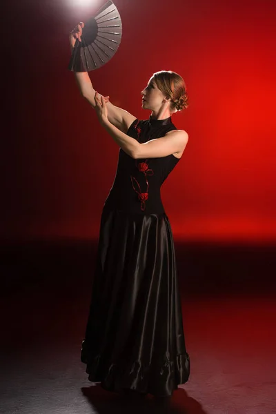 Muito dançarina de flamenco no vestido segurando ventilador acima da cabeça no vermelho — Fotografia de Stock