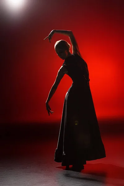 Silhouette einer jungen Frau, die Flamenco auf Rot tanzt — Stockfoto