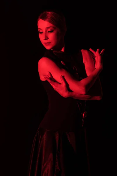 Red lighting on young woman dancing flamenco isolated on black — Stock Photo