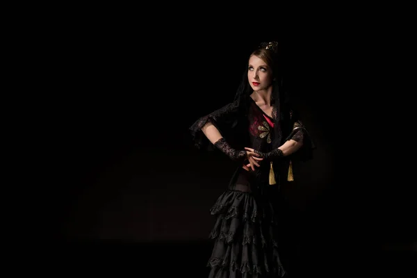 Hübsche junge Flamenco-Tänzerin steht isoliert auf schwarz — Stockfoto