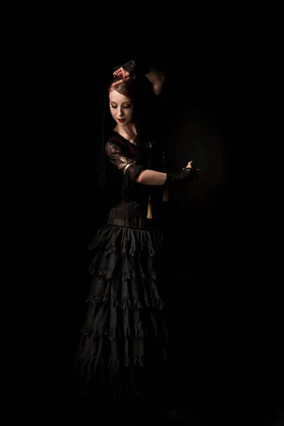 Graziosa giovane ballerina di flamenco che balla in abito isolato sul nero — Foto stock