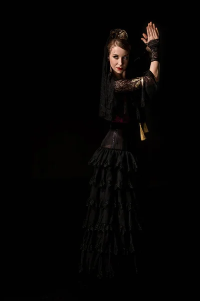 Attractive young flamenco dancer dancing and clapping hands isolated on black — Stock Photo