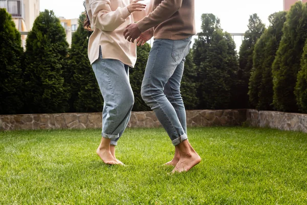 Abgeschnittene Ansicht eines Paares, das draußen auf grünem Gras tanzt — Stockfoto