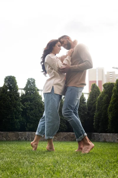 Felice coppia in piedi e abbracci su erba verde al di fuori — Foto stock