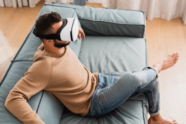 Overhead view of bearded man in virtual reality headset in living room — Stock Photo