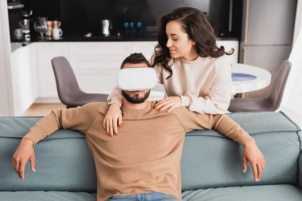 Attractive girl looking at bearded boyfriend in virtual reality headset — Stock Photo