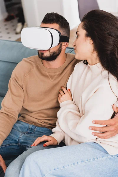 Jeune femme regardant petit ami barbu en réalité virtuelle casque — Photo de stock