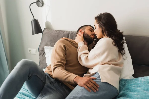 Beautiful girl and handsome man with closed eyes hugging while lying on bed — Stock Photo