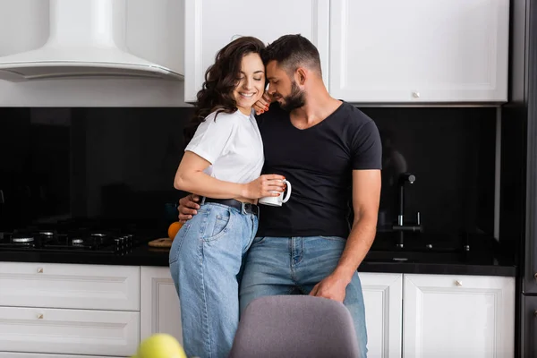 Enfoque selectivo de hombre feliz cerca de chica sonriente sosteniendo taza de café - foto de stock