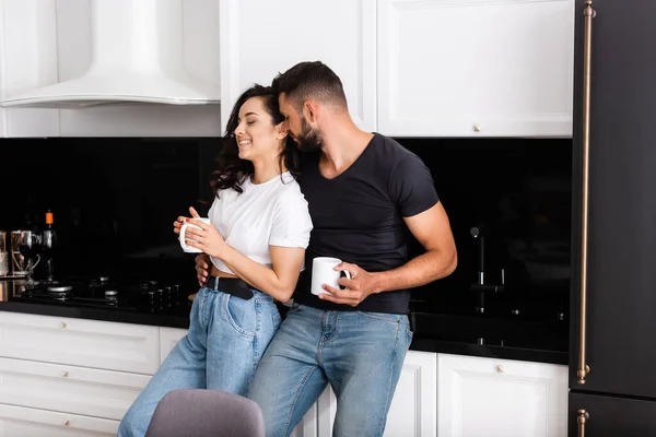 Bearded man and cheerful woman holding cups of coffee — Stock Photo