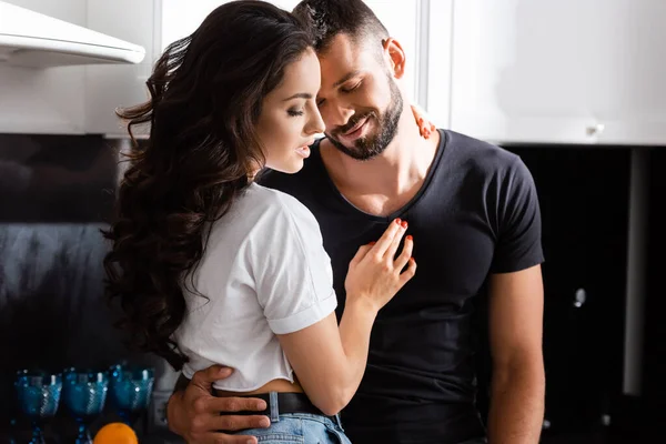 Attractive girl hugging bearded boyfriend at home — Stock Photo