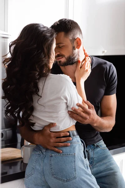 Mujer joven abrazando novio barbudo con los ojos cerrados - foto de stock