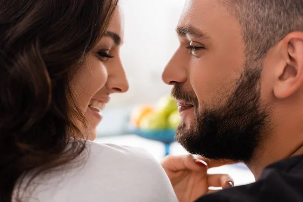 Vista lateral de una pareja sonriente mirándose en casa - foto de stock