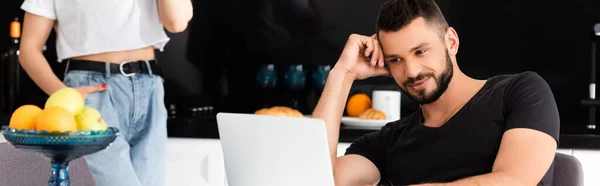 Horizontal image of happy freelancer using laptop near girl — Stock Photo