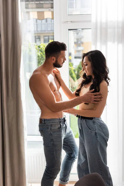 Profile of muscular man touching attractive young woman at home — Stock Photo