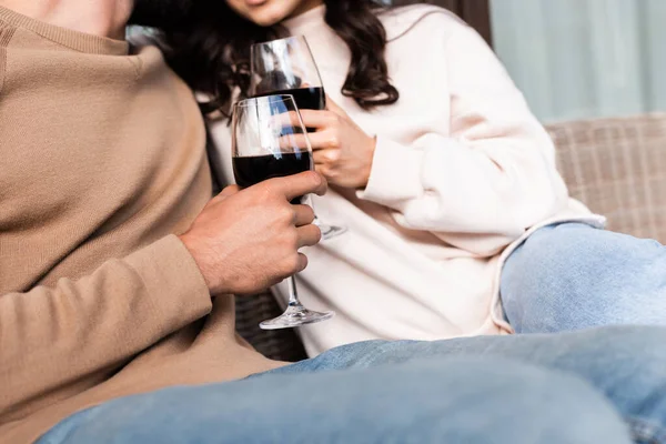 Cropped view of woman and man holding glasses of red wine outside — Stock Photo