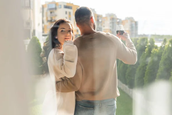 Selective focus of man holding wine glass and hugging attractive girlfriend outside — Stock Photo