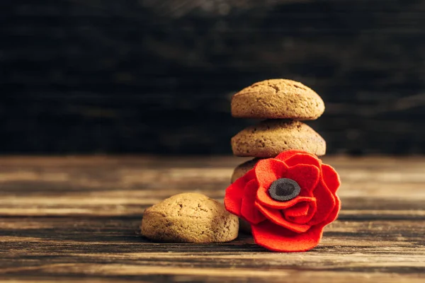 Flor artificial e biscoitos na superfície de madeira, conceito de dia anzac — Fotografia de Stock