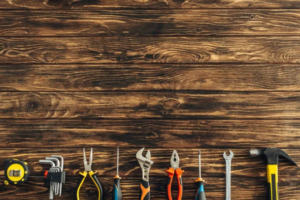 Vista superior de instrumentos metálicos en la superficie de madera, concepto del día del trabajo - foto de stock