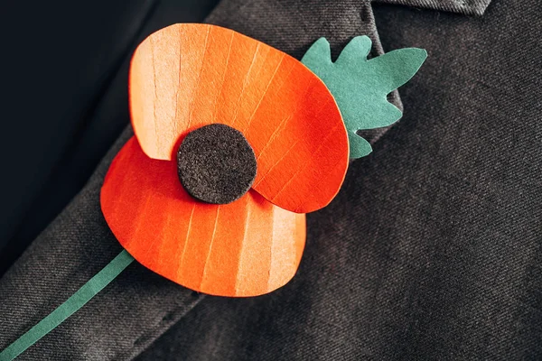 Close up of orange felt flower with green leaf on jacket — Stock Photo
