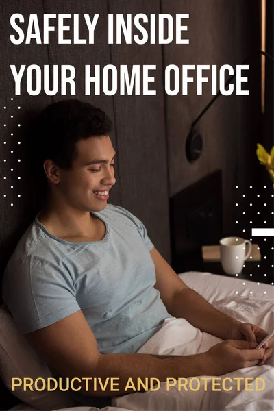 Happy mixed race man using smartphone near safely inside your home office, productive and protected lettering in bedroom — Stock Photo