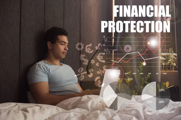 Handsome mixed race freelancer using laptop near financial protection lettering, money signs, charts and graphs — Stock Photo