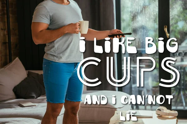 Abgeschnittene Ansicht des Mannes mit Tasse Kaffee mit Fernbedienung in der Nähe Ich mag große Tassen und ich kann nicht lügen Schriftzug — Stockfoto