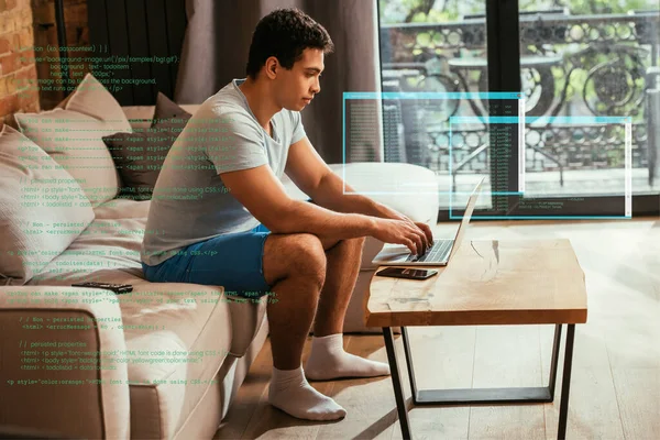 Joven carrera mixta freelancer trabajando desde casa con el ordenador portátil cerca de datos virtuales ilustración - foto de stock