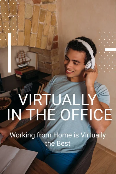 Souriant mixte homme touchant écouteurs près pratiquement dans le bureau, travailler à la maison est pratiquement le meilleur lettrage — Photo de stock