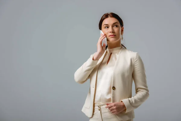 Schöne Geschäftsfrau spricht auf Smartphone isoliert auf grau — Stockfoto