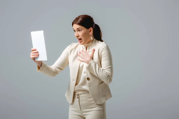 Shocked businesswoman having video call on digital tablet isolated on grey, concept of body positive — Stock Photo