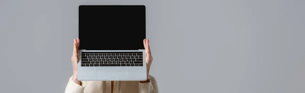 Фотография женщины, держащей ноутбук с экраном, изолированным на сером фоне — стоковое фото
