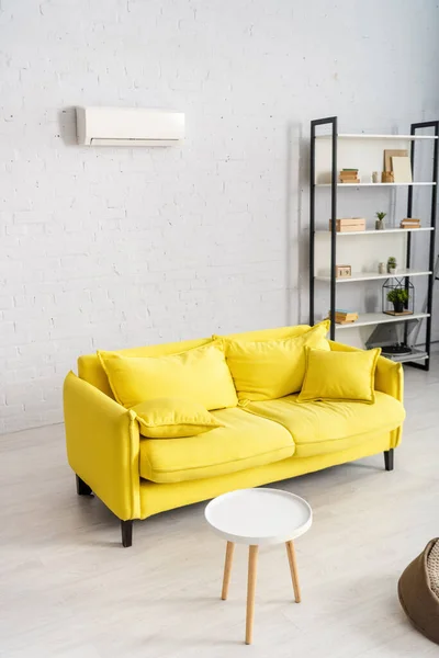 Interior of living room with yellow couch and air conditioner on wall — Stock Photo