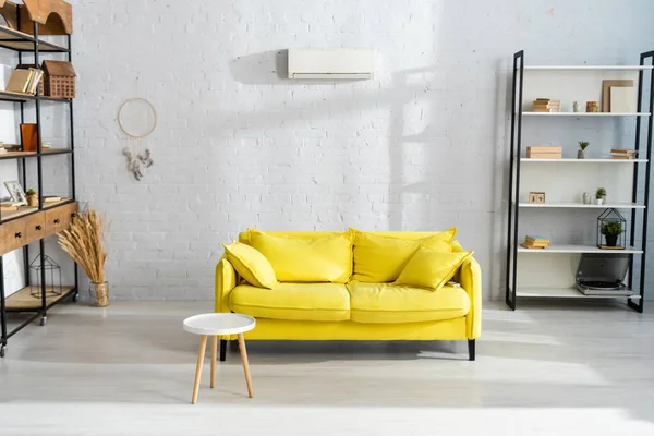 Интерьер гостиной с журнальным столиком рядом с желтым диваном — стоковое фото