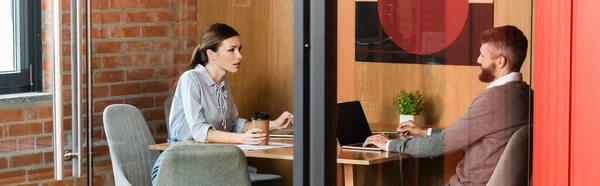 Панорамна орієнтація бізнес-леді тримає паперовий стакан біля бізнесмена — стокове фото