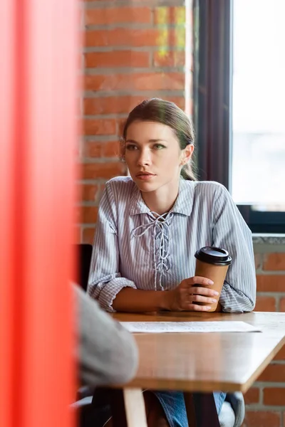 Вибірковий фокус бізнес-леді тримає паперову чашку з кавою, щоб піти і дивитися на бізнесмена — стокове фото