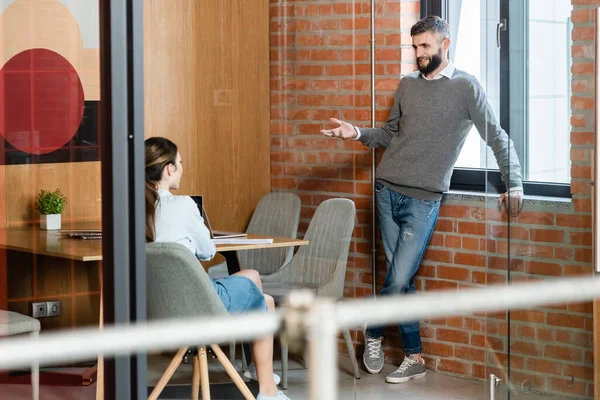 Foco seletivo do empresário feliz gestos e olhando para o colega de trabalho — Fotografia de Stock